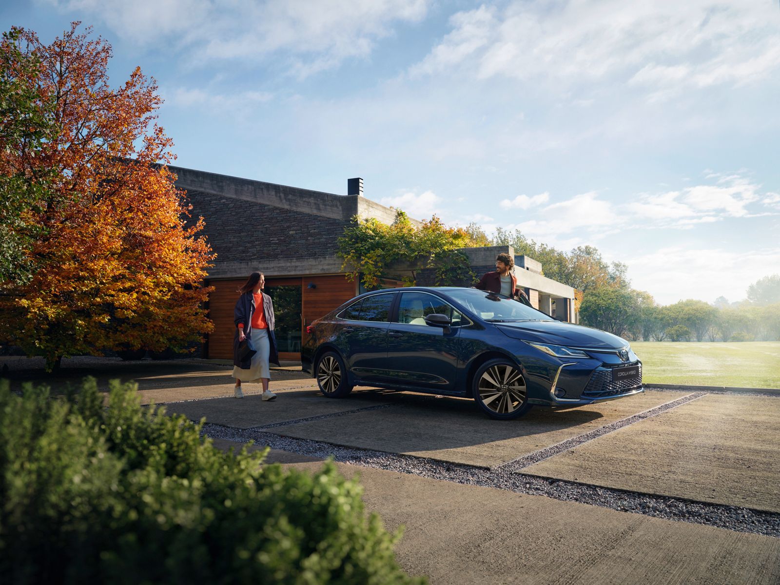 An owner walking towards their Toyota Corolla Sedan