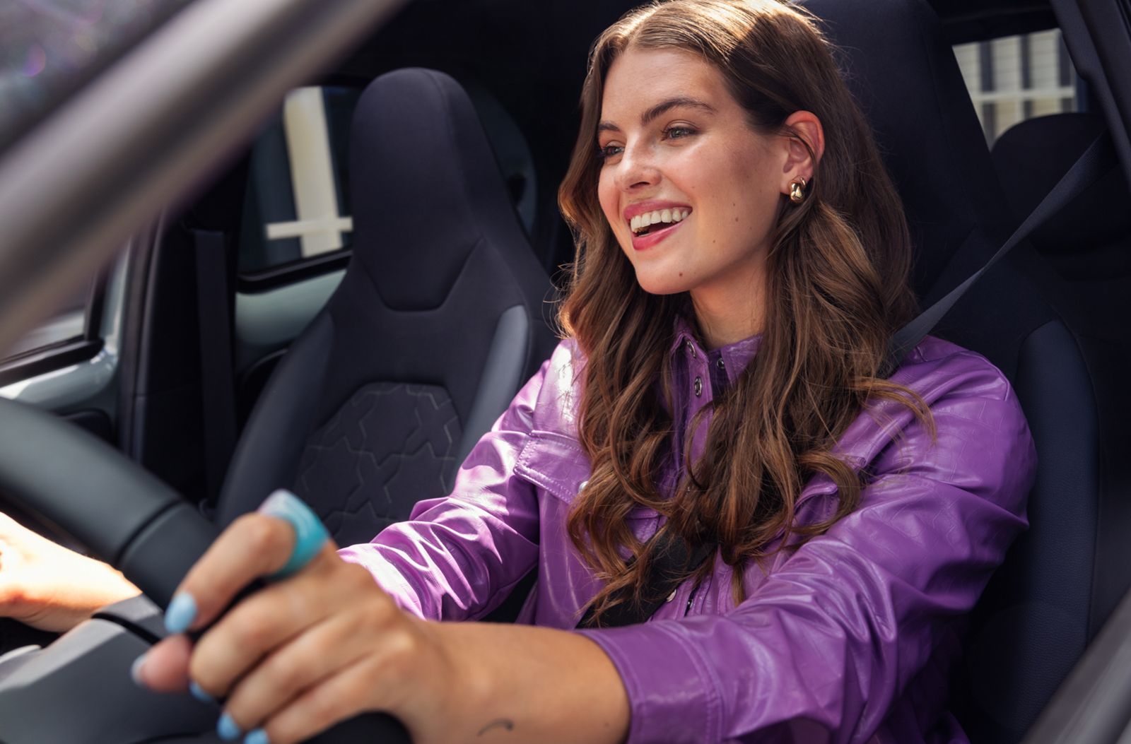 A woman enjoying driving a Aygo X